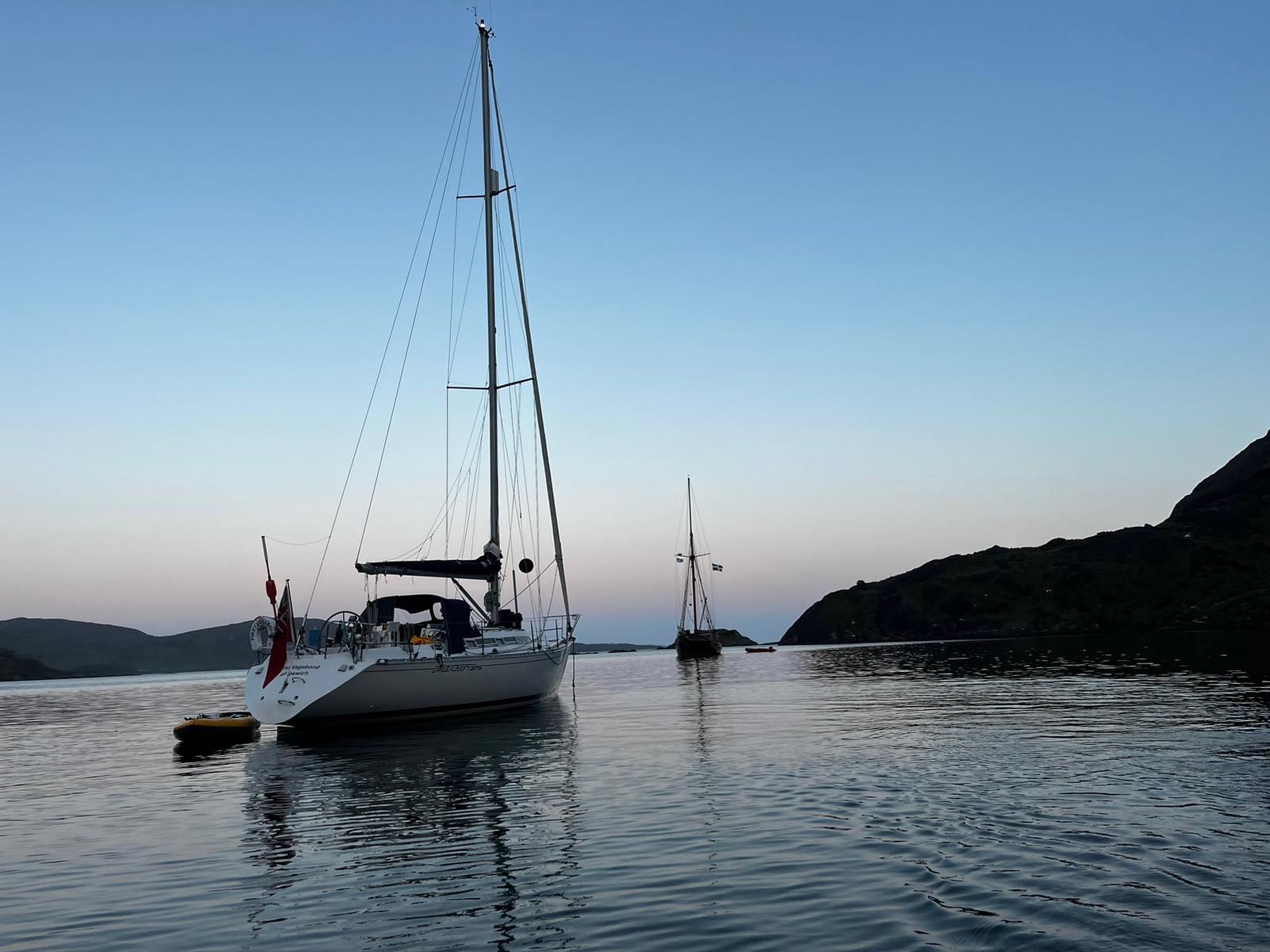 Yachts at anchor in a quiet bay at dusk